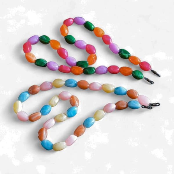 Cordon de lunettes Perles baroques très résistant et léger. 2 modèles proposés : cordon / perles légères acidulées fuchsia, orange, vert, mauve et cordon / perles légères bleu ciel, caramel au lait, rose crème. Système de fixation Classique : Ses boucles en caoutchouc ultra résistantes garantissent une fixation sûre et en font un produit durable. Taille disponible : 65 cm. Modèle : gourmande