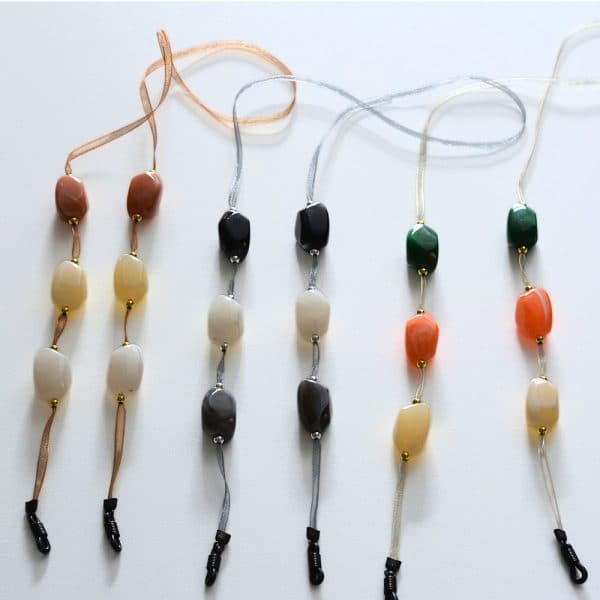 Cordon de lunettes Mousseline Perles baroques et perles métal doré ou argenté Cordon ruban en mousseline très résistant, finition noire. 3 combinaisons de coloris proposées : cordon mousseline gris / perles baroques noir, blanc, gris / perles étal argenté cordon mousseline beige / perles baroques orange, vert, blanc / perles métal doré cordon mousseline marron / perles baroques caramel au lait, crème, blanc / perles métal doré Système de fixation Classique : Ses boucles en caoutchouc ultra résistantes garantissent une fixation sûre et en font un produit durable. Taille disponible 65 cm. Modèle : Gourmandise